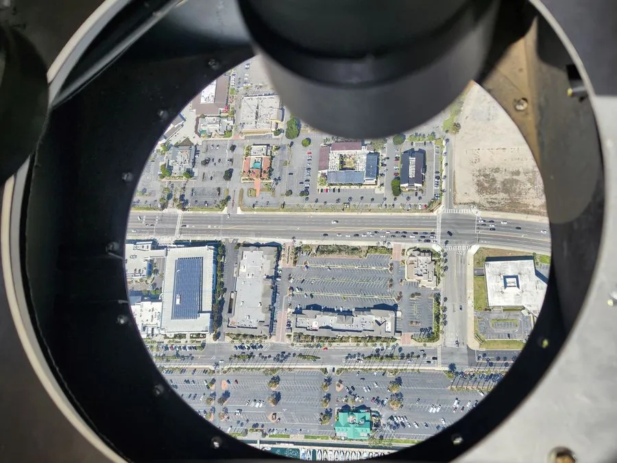 View through aircraft camera port over urban intersection