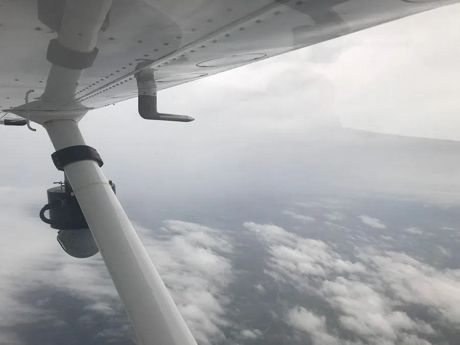 Aircraft in flight above clouds on emergency response mission